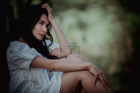 Téléchargez les photos : Asiatique belle fille se sentent seuls dans la forêt, concept de femme triste, Thaïlande gens, Lady tristesse au sujet de l'amour de petit ami, Elle se sent le cœur brisé - en image libre de droit