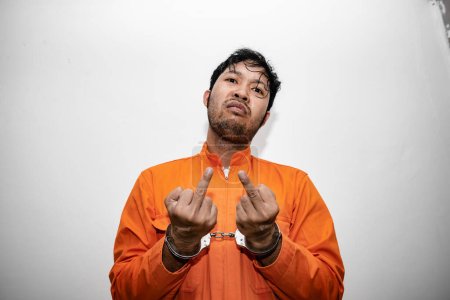 Foto de Prisoner in orange robe concept,Portrait of asian handsome man in Prison uniforms,Bandit has a lot of muscle, - Imagen libre de derechos