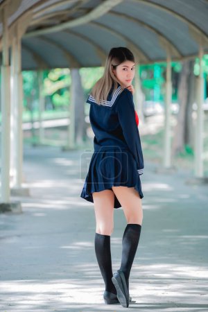 Téléchargez les photos : Portrait de femme asiatique porter robe étudiante style japonais, Thaïlande personnes, pose fille mignonne pour prendre une photo, Style de vie de la femme moderne - en image libre de droit