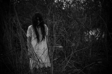 Foto de Portrait of asian woman make up ghost face at the swamp,Horror in water scene,Scary at river,Halloween poster,Thailand people - Imagen libre de derechos