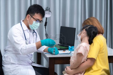 Foto de Parents bring their daughter to the doctor for influenza vaccination,The mother brought the child to the doctor at the clinic. - Imagen libre de derechos
