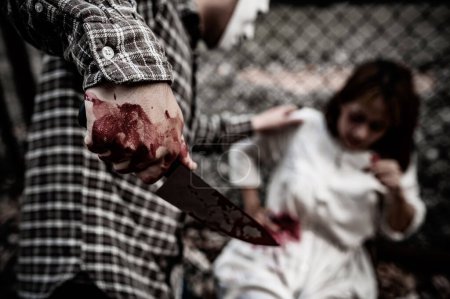 Téléchargez les photos : Une scène de tueur en série est sur le point de tuer une femme asiatique, concept thriller scene, Halloween festival - en image libre de droit