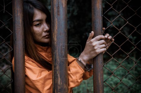 Téléchargez les photos : Portrait de femmes désespérées d'attraper la prison de fer, concept de prisonnier, thailand personnes, Espérance d'être libre, Si la violation de la loi serait arrêté et emprisonné. - en image libre de droit