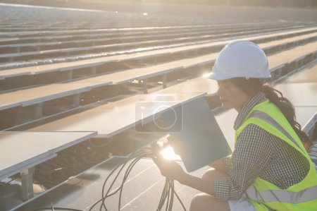 Téléchargez les photos : Ingénieur asiatique travaillant chez Floating Solar Farm, Energie renouvelable, Technicien et investisseur panneaux solaires vérifiant les panneaux à l'installation d'énergie solaire - en image libre de droit
