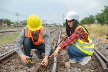 Foto de Dos ingenieros que trabajan en la estación de tren, trabajan juntos felizmente, se ayudan mutuamente a analizar el problema, consultan sobre las directrices de desarrollo - Imagen libre de derechos