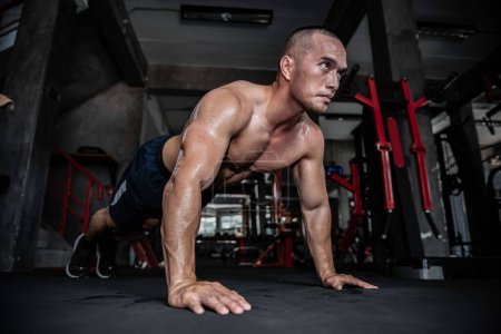 Téléchargez les photos : Portrait de l'homme asiatique gros muscle à la salle de gym, Thaïlande personnes, Entraînement pour une bonne santé, Entraînement de poids corporel, Fitness au concept de salle de gym, Prank to abdominal muscles - en image libre de droit