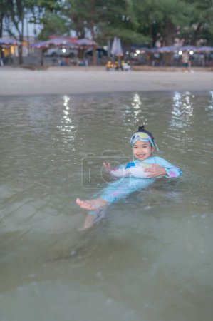 Téléchargez les photos : Asian girl play sea with fun,Summer time with family,Children's semester break activities - en image libre de droit