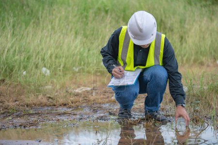 Foto de Ingenieros ambientales inspeccionan la calidad del agua, traen agua al laboratorio para pruebas, verifican el contenido mineral en el agua y el suelo, verifican si hay contaminantes en las fuentes de agua. - Imagen libre de derechos