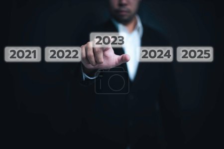 Téléchargez les photos : Man press botton next to new year,Welcome the coming year 2023. - en image libre de droit