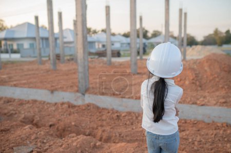 Téléchargez les photos : Ingénieur concept enfant, Asiatique petite fille porter ingénieur uniforme de travail sur le site du bâtiment - en image libre de droit