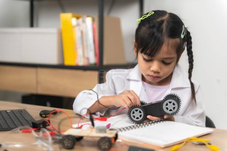 Foto de Asiático niña pequeña construcción y codificación robot en la clase STEM, Fijación y reparación de coches de juguete mecánico - Imagen libre de derechos