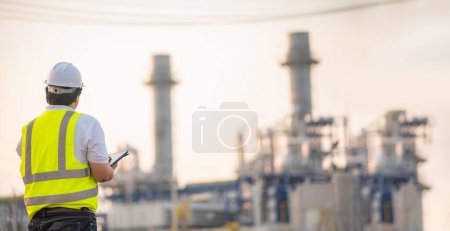 Foto de El hombre asiático ingeniero petroquímico que trabaja en la fábrica de la industria de la planta de refinería de petróleo y gas, el trabajador del pueblo ingeniero de control de trabajo en la industria de energía de la planta de energía de fabricación - Imagen libre de derechos