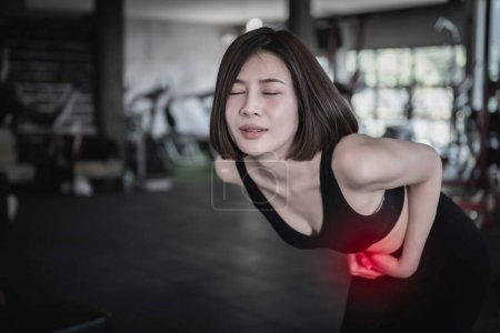 Photo for Asian slim woman play fitness at the gym,She pain from exercise - Royalty Free Image
