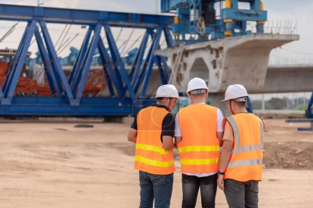 Photo for Group of asian engineers discuss about work at site of building under construction,The contractor team discusses the design of the structure,Three workers are working outside. - Royalty Free Image
