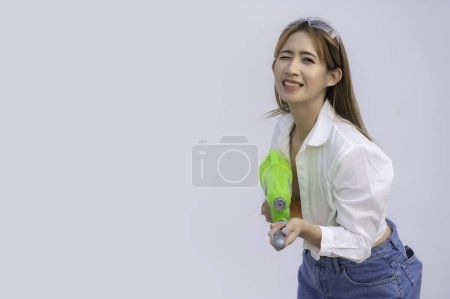 Téléchargez les photos : Asiatique femme sexy avec de l'eau à la main sur fond blanc, Festival songkran jour à thailand, Le meilleur de festival de thai, Terre de sourire - en image libre de droit