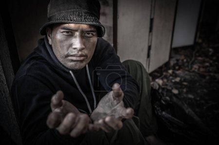 Foto de Hombre asiático está sin hogar en el camino lateral, un extraño tiene que vivir solo en el camino porque no tiene familia. - Imagen libre de derechos