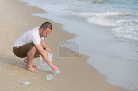 Photo for Asian man keep garbage at inside sea beach,people volunteer keeping garbage plastic bottle - Royalty Free Image