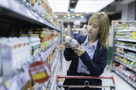 Foto de Asiático hermosa mujer compras con carrito en supermercado - Imagen libre de derechos