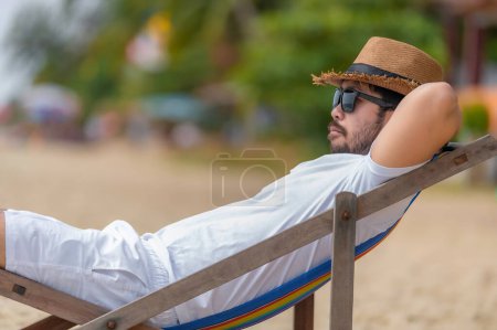 Téléchargez les photos : Asiatique homme assis chaise plage à l'intérieur de la mer, Relax time at summer - en image libre de droit