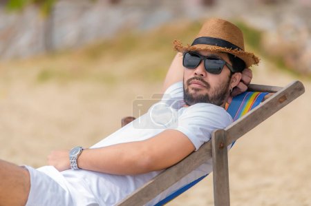 Téléchargez les photos : Asiatique homme assis chaise plage à l'intérieur de la mer, Relax time at summer - en image libre de droit