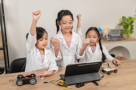 Téléchargez les photos : Asiatique petite fille construction et codage robot à la classe STIM, Fixation et réparation mécanicien jouet voiture - en image libre de droit
