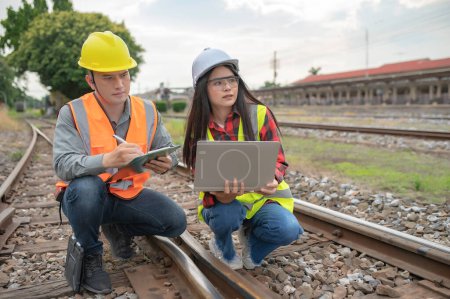 Dos ingenieros que trabajan en la estación de tren, trabajan juntos felizmente, se ayudan mutuamente a analizar el problema, consultan sobre las directrices de desarrollo