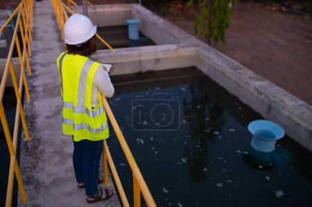 Téléchargez les photos : Ingénieurs de l'environnement travaillent dans les usines de traitement des eaux usées, Ingénierie de l'approvisionnement en eau travaillant à l'usine de recyclage de l'eau pour la réutilisation, Vérifiez la quantité de chlore dans l'eau pour être dans les critères. - en image libre de droit