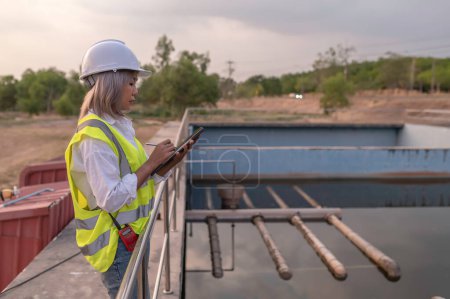 Photo for Environmental engineers work at wastewater treatment plants,Water supply engineering working at Water recycling plant for reuse,Technicians and engineers discuss work together. - Royalty Free Image