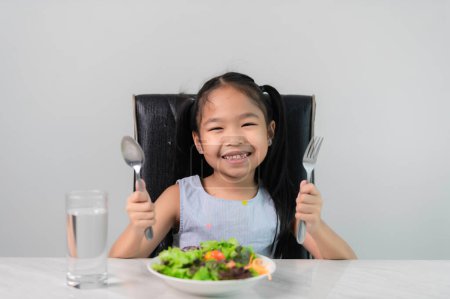 Photo for Little asian cute girl to eat healthy vegetables.Nutrition and healthy eating habits for kids concept.Children happy and like to eat vegetables. - Royalty Free Image
