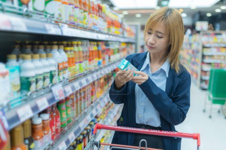 Téléchargez les photos : Asiatique belle femme shopping avec panier au supermarché - en image libre de droit