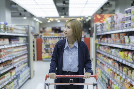 Foto de Asiático hermosa mujer compras con carrito en supermercado - Imagen libre de derechos