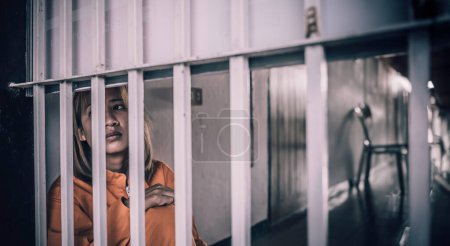 Téléchargez les photos : Portrait de femmes désespérées d'attraper la prison de fer, concept de prisonnier, thailand personnes, Espérance d'être libre, Si la violation de la loi serait arrêté et emprisonné. - en image libre de droit