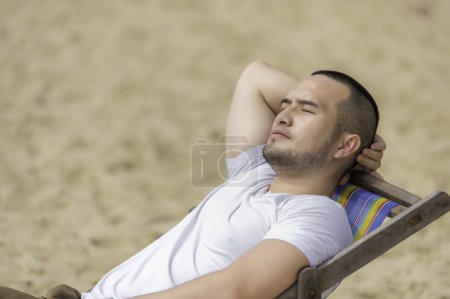 Photo for Asian man sitting chair beach inside sea,Relax time at summer - Royalty Free Image
