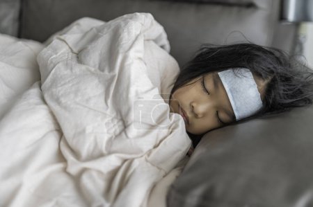 Téléchargez les photos : Petite fille asiatique malade à la maison, Malade avec la grippe qui vient de l'école - en image libre de droit