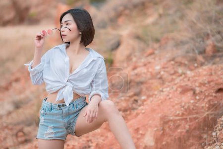 Téléchargez les photos : Portrait de belle femme asiatique porter chemise blanche et denim court, Thaïlande personnes, Pose pour prendre une photo, Femme sexy - en image libre de droit
