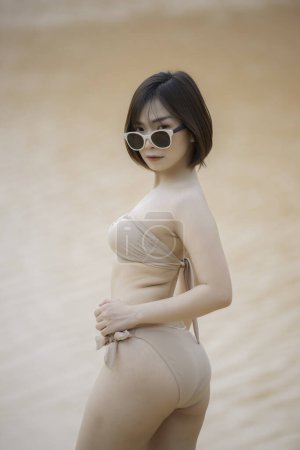 Foto de Retrato de joven asiática hermosa mujer usar bikini lado río en la luz del día. Tailandia gente. Concepto de moda de verano. Tiempo de relajación - Imagen libre de derechos