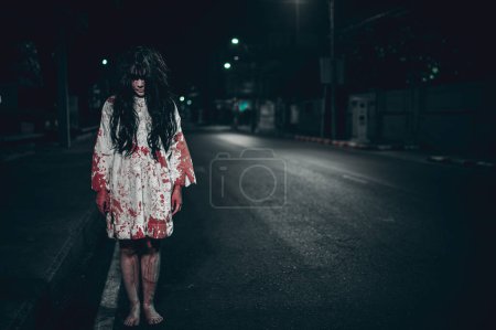 Téléchargez les photos : Concept de femme d'horreur. Fantôme sur la route dans la ville. Un esprit vengeur dans la rue de la ville. Festival d'Halloween. Maquiller le visage fantôme - en image libre de droit