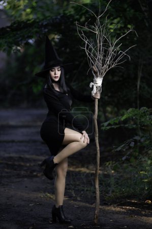 Foto de Retrato de hermosa mujer sexy asiática usar traje de bruja negro con escoba, concepto de festival de Halloween - Imagen libre de derechos