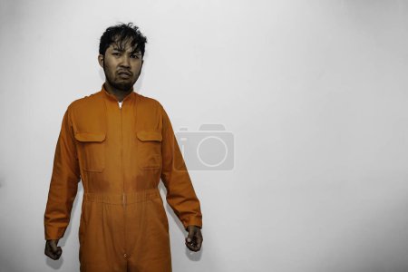 Foto de Prisionero en concepto de túnica naranja. Retrato de un hombre guapo asiático en uniforme de prisión. Bandido tiene un montón de músculos - Imagen libre de derechos