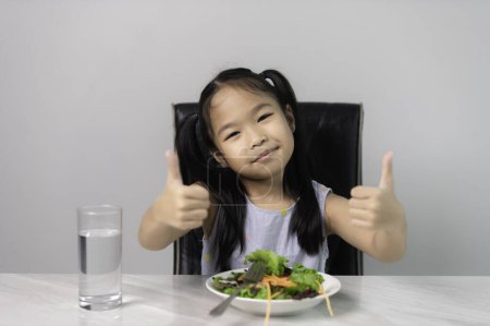 Photo for Little asian cute girl to eat healthy vegetables. Nutrition and healthy eating habits for kids concept. Child happy and like to eat vegetables. - Royalty Free Image