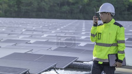 Foto de Ingeniero asiático trabajando en planta de energía solar flotante. Energía renovable. Técnico e inversor de paneles solares comprobar los paneles en la instalación de energía solar - Imagen libre de derechos