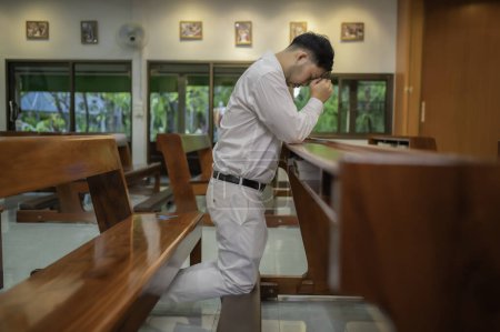 Foto de El hombre cristiano pide bendiciones a Dios. Hombre asiático rezando a Jesucristo - Imagen libre de derechos