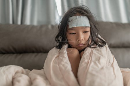 Téléchargez les photos : Petite fille asiatique malade à la maison. Malade avec la grippe qui vient de l'école - en image libre de droit