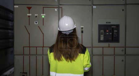 Photo for Asian electric engineer holding clipboard for checking and monitoring the electrical system in the control room. Technician thailand people working - Royalty Free Image