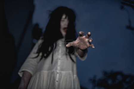 Foto de Retrato de mujer asiática que maquilla la cara de fantasma con sangre. Escena de horror. Fondo aterrador. Cartel de Halloween. Tailandia personas - Imagen libre de derechos