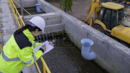 Photo for Environmental engineer work at wastewater treatment plant. Water supply engineering working at Water recycling plant for reuse. Check the amount of chlorine in the water to be within the criteria. - Royalty Free Image