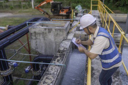 Téléchargez les photos : Ingénieur en environnement travaille dans les usines de traitement des eaux usées. Ingénierie de l'approvisionnement en eau travaillant à l'usine de recyclage de l'eau - en image libre de droit