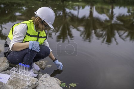 Téléchargez les photos : Ingénieur environnemental inspecter la qualité de l'eau. Apportez de l'eau au labo pour les tests. Vérifier la teneur en minéraux de l'eau et du sol. Recherche de contaminants dans les sources d'eau. - en image libre de droit