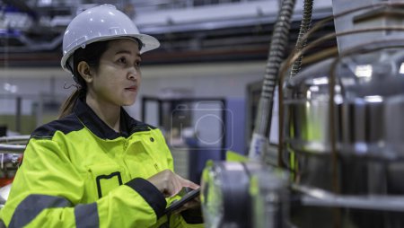 Foto de Ingeniero asiático trabajando en la sala de operaciones. Tailandia la gente usa casco de trabajo. Trabajó con diligencia y paciencia, ella comprobó el regulador de válvulas en el tanque de hidrógeno. - Imagen libre de derechos