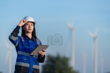 Téléchargez les photos : Ingénieur travaillant et tenant le rapport à la centrale éolienne sur montagne. Thaïlande peuple - en image libre de droit